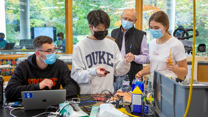 Bastiaan Driehuys, professor of radiology and physics, helps first-year students Mike Lund, Jaeyoung Kil and Megan Flanigan on a client project during EGR 101. The students were engineering a device to warm mannequin skin for the Duke School of Nursing. Photo: Jared Lazarus/Duke University