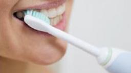 Electric toothbrush with suction attachment